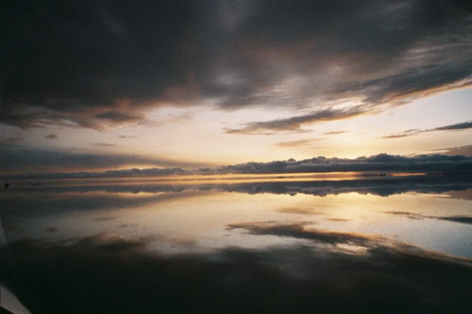 Storm clouds mirrored perfectly in the flooded Salar de Uyuni at sunset