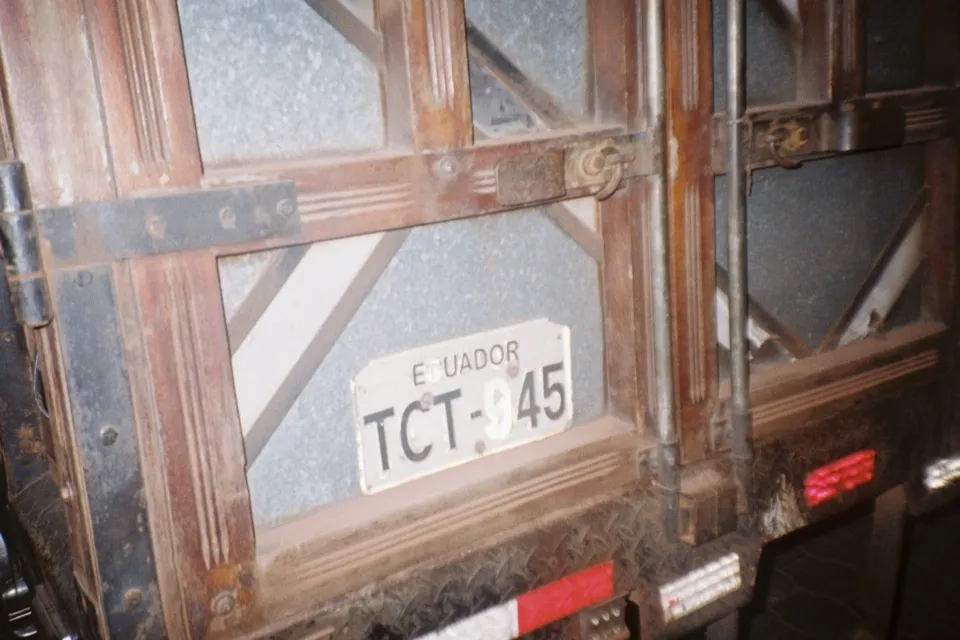 The rusted tailgate of a truck with an Ecuador number plate